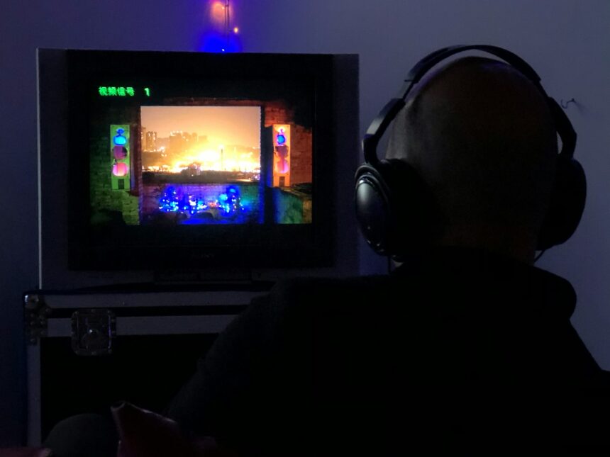a man sitting in front of a tv with headphones on